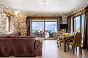 ein Wohnzimmer mit Sofa und Tisch in der Unterkunft VillasGoudis Evelynn in Tsoukaladhes