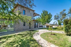 einen Blick auf ein Steinhaus mit Garten in der Unterkunft VillasGoudis Evelynn in Tsoukaladhes