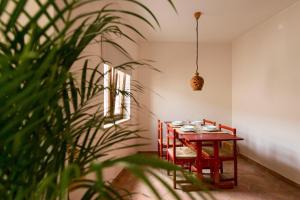 ein Esszimmer mit einem Tisch, Stühlen und einer Pflanze in der Unterkunft Unique Home In Historic Centre in Lagos