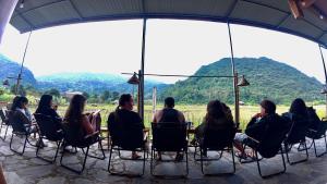 a group of people sitting at a table with mountains in the background at Expeditions home in Ha Giang