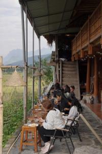 a group of people sitting at tables in a building at Expeditions home in Ha Giang