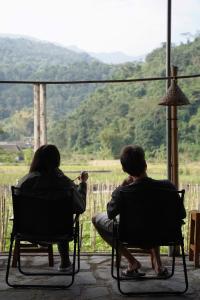two people sitting in chairs looking out of a window at Expeditions home in Ha Giang