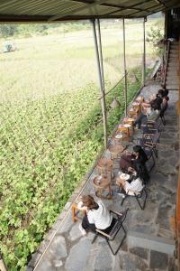 a group of people sitting in chairs in a field at Expeditions home in Ha Giang