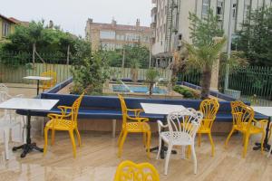 a patio with yellow chairs and tables and a pool at Kaya Palas Hotel in Kırklareli