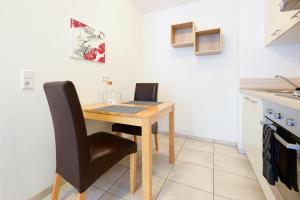 a small kitchen with a wooden table and two chairs at 7SCHWABEN 1 Haus 7 unterschiedliche Wohnungen alle vollausgestattet mit Küche und Bad, Waschmaschine, Altstadt 3 Minuten, Bus 3 min, Bahn 5 min, kostenloses Parken, E-Bike Garage Ladestation im Hof, E-Ladestation 3 min, rollstuhlgerecht, barrierefrei in Bad Urach +30 photos