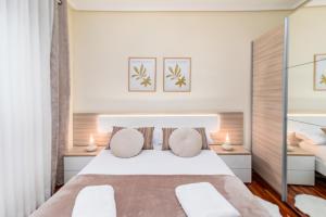 Un dormitorio con una cama blanca con dos lámparas. en Apartamento PEDREGAL en el CASCO HISTÓRICO, en Castro Urdiales 9 fotos más