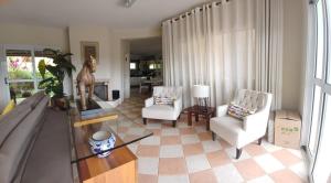 un soggiorno con due sedie e un tavolo di Represa de Igaratá Yellow House a Jacareí