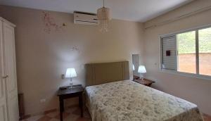 una camera da letto con un letto e due lampade sui tavoli di Represa de Igaratá Yellow House a Jacareí Altre 22 foto