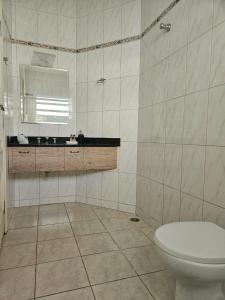 un bagno bianco con un water e un lavandino di Represa de Igaratá Yellow House a Jacareí