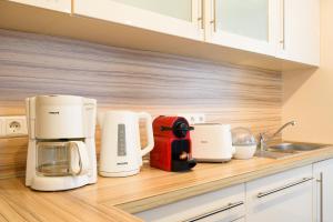 a kitchen with white appliances on a wooden counter at 7SCHWABEN 1 Haus 7 unterschiedliche Wohnungen alle vollausgestattet mit Küche und Bad, Waschmaschine, Altstadt 3 Minuten, Bus 3 min, Bahn 5 min, kostenloses Parken, E-Bike Garage Ladestation im Hof, E-Ladestation 3 min, rollstuhlgerecht, barrierefrei in Bad Urach
