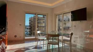 een eetkamer met een tafel en een groot raam bij Olimpia in Arma di Taggia