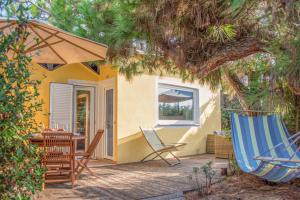a patio with a hammock and a table and chairs at Resort Riva Degli Etruschi in San Vincenzo