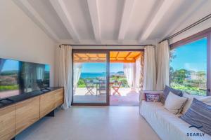 Punta MolaraVilla Piperita - By Searly的带沙发和电视的客厅以及阳台。