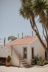 ein kleines weißes Haus mit einer Treppe und einer Palme in der Unterkunft Monte Meu in Odemira