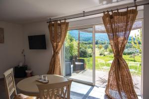 a dining room with a table and a large window at Logis Hôtel La Bastide des Monges in Nyons