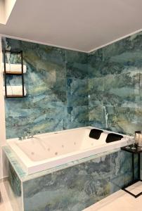 Una bañera en un baño con azulejos azules. en Ladi House, en Nola