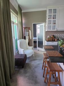 a living room with a table and a chair at GreenHouse BoKaap Stylish Apartment with Table Mountain Views in Cape Town +15 photos