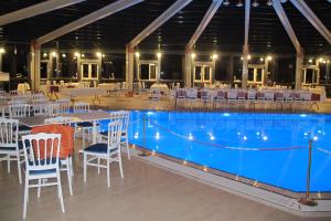 a pool with white chairs and tables and a wedding reception at Kaya Palas Hotel in Kırklareli