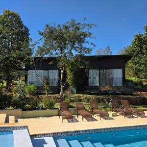 a house with a swimming pool and lounge chairs at Tupa Lodge Selva y Rio in Puerto Iguazú