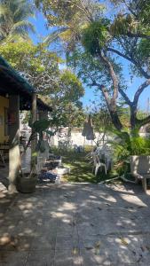 un patio con sillas y sombrillas en una playa en El Gringo Banheiro Compartilhado, en Cabo de Santo Agostinho