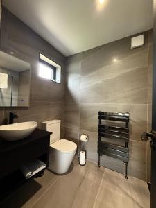 Un baño con un inodoro blanco y un lavabo. en The Inn on the Loch, en Castle Douglas