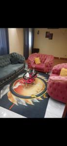 Villa de luxe LE HAVRE DE JOIE ET DE PAIX 300m2 de superficie Wifi illimité forage et grande cour pour garer plusieurs voitures ou organisation celebrations في دوالا: غرفة معيشة مع أريكتين وطاولة