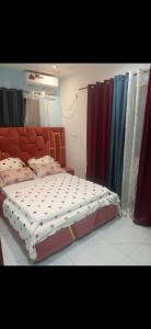 Villa de luxe LE HAVRE DE JOIE ET DE PAIX 300m2 de superficie Wifi illimité forage et grande cour pour garer plusieurs voitures ou organisation celebrations في دوالا: غرفة نوم بسرير كبير وستائر