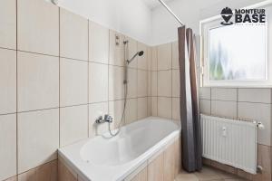 Un baño con bañera y ventana. en MONTEUR - Unterkunft für bis zu 5 Personen in 63452 Hanau - HU14, en Hanau am Main