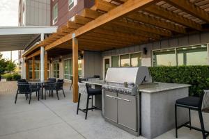 レイクランドにあるTownePlace Suites by Marriott Lakelandのグリルとテーブルと椅子のあるパティオ