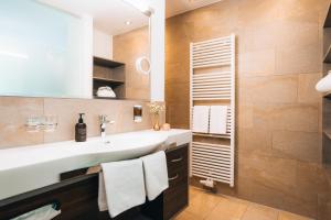 ザンクト・アントン・アム・アールベルクにあるホテル ナッセライナーホーフの洗面台と大きな鏡のあるバスルーム