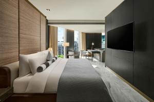 a bedroom with a large bed and a television at Madison Taipei, a Tribute Portfolio Hotel in Taipei