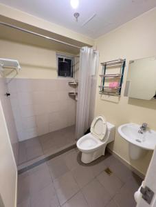 ein Badezimmer mit Toilette und Waschbecken in der Unterkunft Leo's Master bedroom in Manila