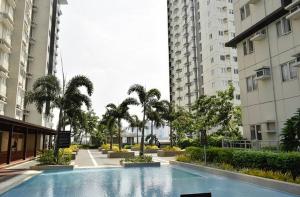 ein Schwimmbad in der Mitte von zwei Gebäuden in der Unterkunft Leo's Master bedroom in Manila