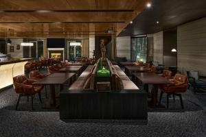 a dining room with wooden tables and chairs at Madison Taipei, a Tribute Portfolio Hotel in Taipei