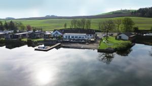 una vista aérea de una casa junto a un lago en The Inn on the Loch, en Castle Douglas