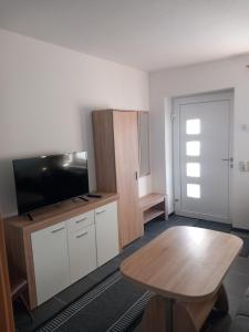 een kamer met een tafel en een flatscreen-tv bij Ferienwohnungen Albinshof in Krien