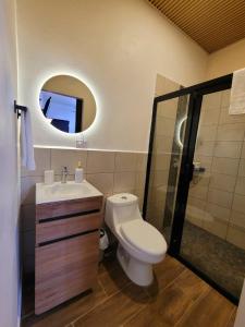 a bathroom with a toilet and a sink and a mirror at Casco histórico- Estación 1501 Duplex in Juticalpa