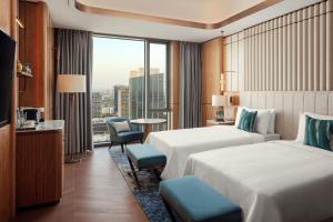 Una habitación de hotel con dos camas y una gran ventana. en JW Marriott Hotel Tashkent, en Tashkent 52 fotos más