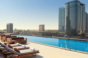 a swimming pool on the roof of a building with a city at JW Marriott Hotel Tashkent in Tashkent