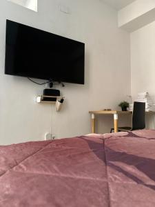 una camera da letto con una TV a schermo piatto sul muro di Molinari House Modena Giada - FREE ZTL a Modena