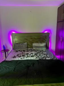 DargaiにあるOne Majestic Havenのベッドルーム(紫色の照明付きのベッド1台付)