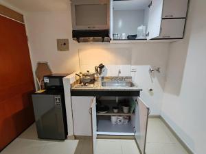 a small kitchen with a sink and a refrigerator at Aparta-estudio acogedor con balcón y parqueadero junto a la UPTC, Tunja in Tunja +1 photo