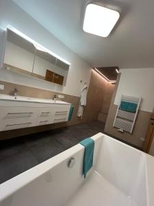 大基希海姆Ferienappartement Sieger的浴室配有大型白色浴缸和水槽