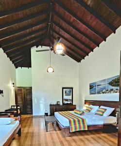 a bedroom with two beds and a wooden ceiling at Heaven in Satinwoods in Tangalle