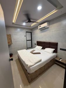 a bedroom with a large bed with white sheets at Hotel castle rooms in Surat