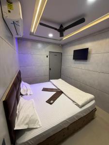 a room with two beds and a tv on the wall at Hotel castle rooms in Surat