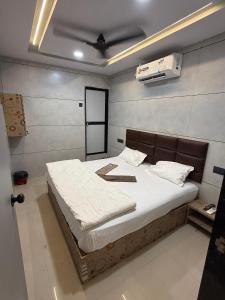 a bedroom with a large bed with white sheets at Hotel castle rooms in Surat