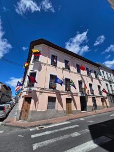 a building with different flags on the side of it at Hostal History in Quito