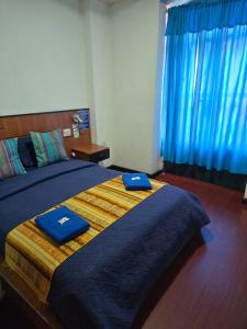 a bedroom with a large bed with blue towels on it at Hostal History in Quito