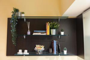 Un estante con libros y plantas en macetas. en Il Rifugio Dei Bizantini, en Rávena